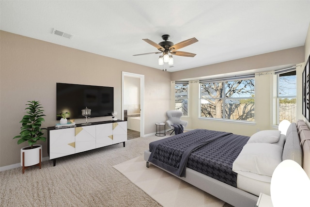 bedroom with connected bathroom, ceiling fan, and light colored carpet