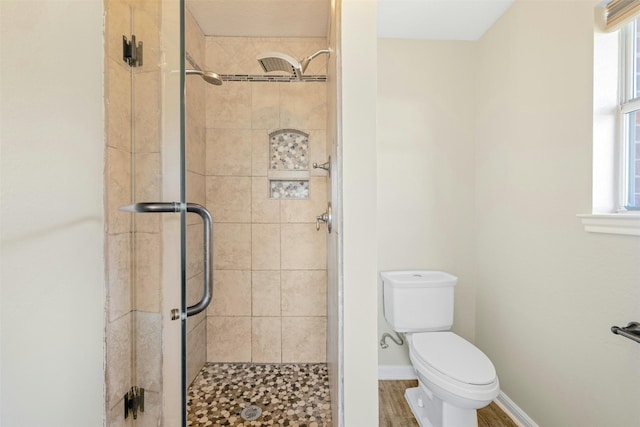 bathroom with toilet, an enclosed shower, and hardwood / wood-style floors