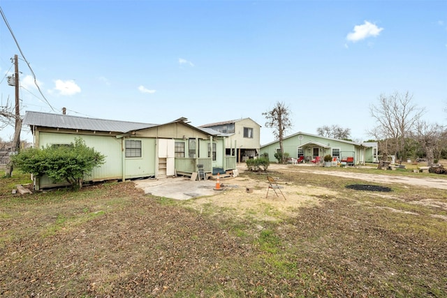 back of house featuring a patio and a lawn