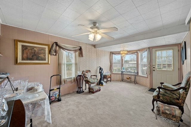 interior space with ceiling fan with notable chandelier, a wealth of natural light, and light colored carpet