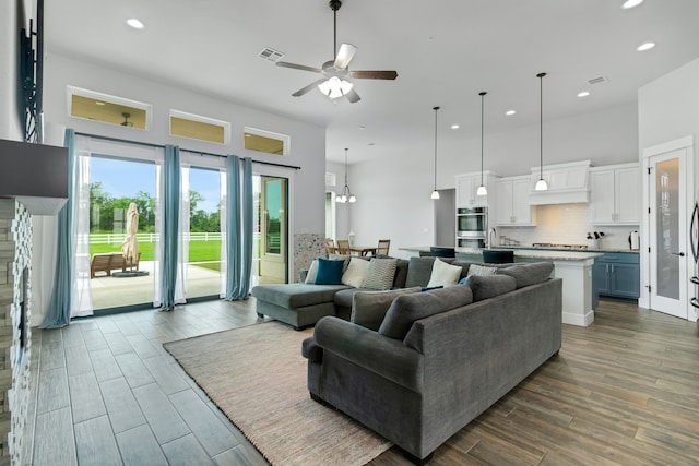 living room with ceiling fan with notable chandelier