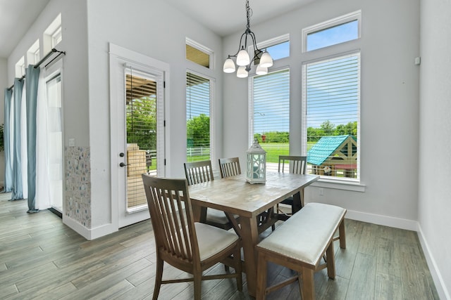 dining area featuring an inviting chandelier, wood-type flooring, and a healthy amount of sunlight