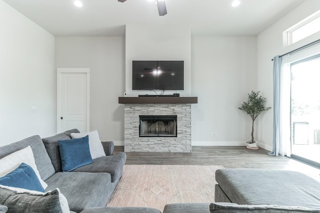 living room with ceiling fan, light hardwood / wood-style floors, and a fireplace