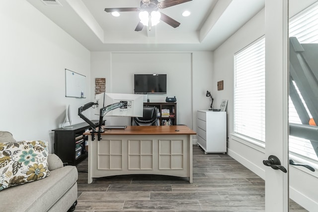 office space with ceiling fan and a tray ceiling