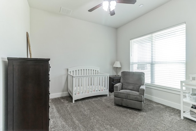 bedroom featuring a crib, carpet flooring, and ceiling fan