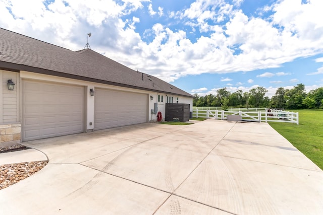 view of side of home featuring a garage and a lawn