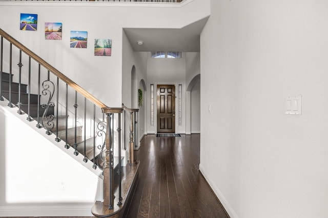 entrance foyer featuring a towering ceiling and hardwood / wood-style flooring