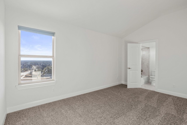 spare room featuring vaulted ceiling and carpet floors