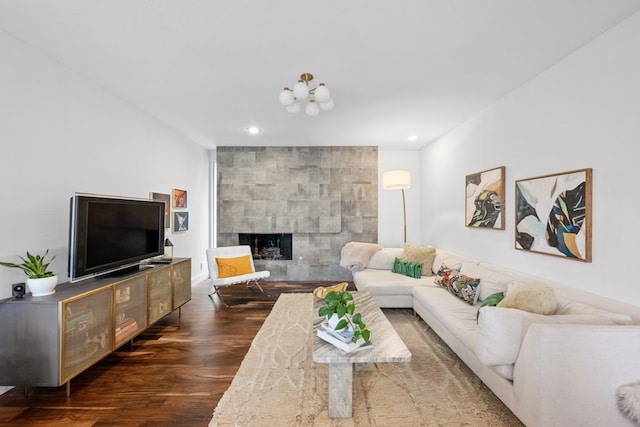 living room with a tiled fireplace and dark hardwood / wood-style floors