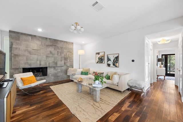 living room featuring a tiled fireplace and wood-type flooring