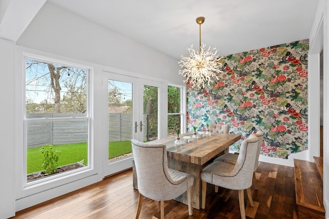 dining space featuring an inviting chandelier, a wealth of natural light, and light hardwood / wood-style floors