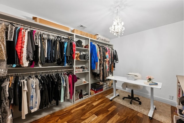 spacious closet featuring a chandelier and hardwood / wood-style flooring