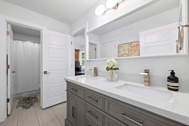 bathroom with curtained shower, vanity, and toilet