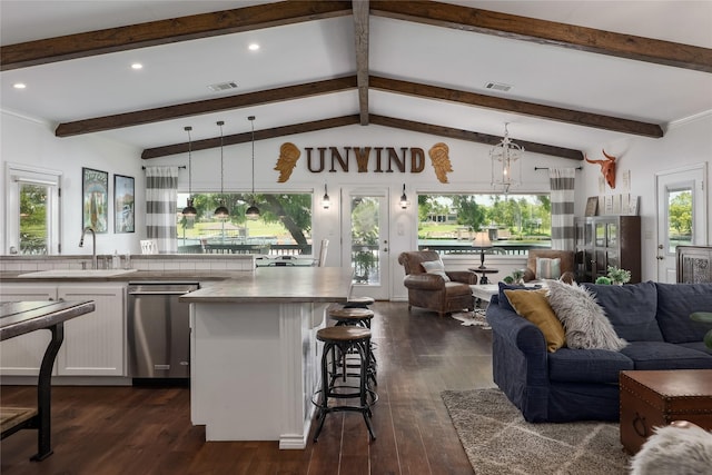 kitchen featuring stainless steel dishwasher, vaulted ceiling with beams, pendant lighting, and dark hardwood / wood-style floors