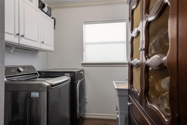 laundry area featuring washing machine and dryer, crown molding, and cabinets