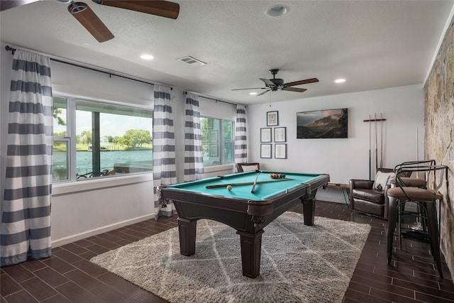 game room featuring a textured ceiling, ceiling fan, billiards, and a water view