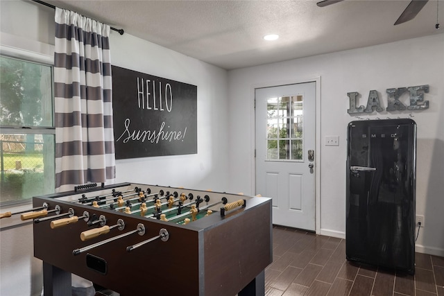 playroom with a textured ceiling and ceiling fan