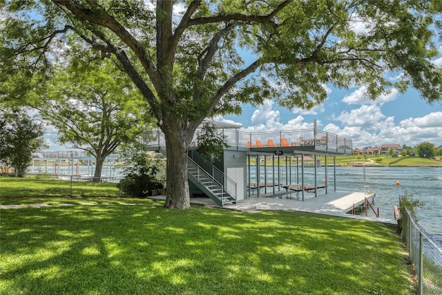 view of dock with a yard and a water view