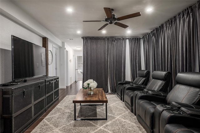 cinema room with hardwood / wood-style flooring and ceiling fan