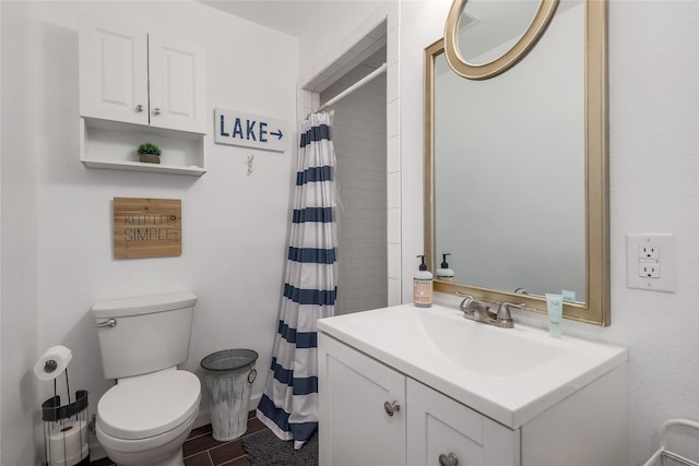 bathroom featuring toilet, walk in shower, and vanity