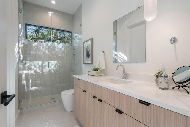 bathroom with toilet, tile patterned flooring, a shower with door, and vanity