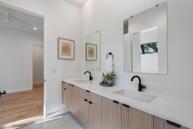 bathroom with hardwood / wood-style floors, vanity, and ceiling fan