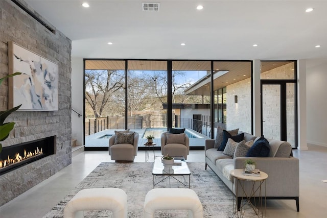 2512 Ridgeview St, Austin, TX 78704 - living room with a wall of windows, a fireplace, finished concrete flooring, recessed lighting, and plenty of natural light