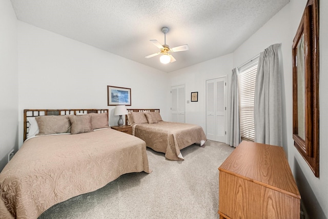 bedroom with a textured ceiling, carpet floors, and ceiling fan