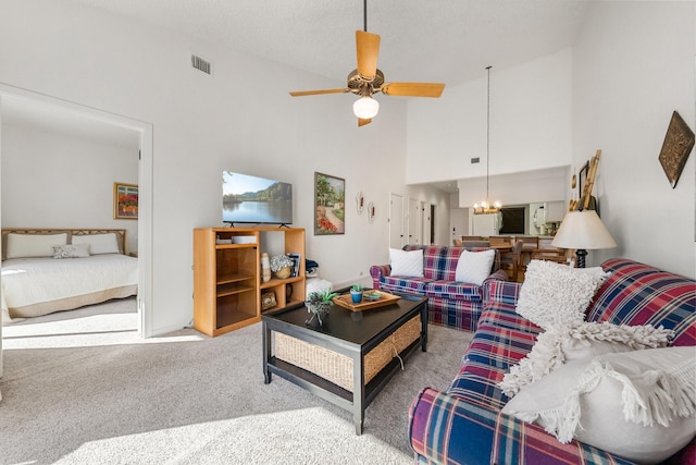 living room featuring ceiling fan with notable chandelier, high vaulted ceiling, and carpet flooring