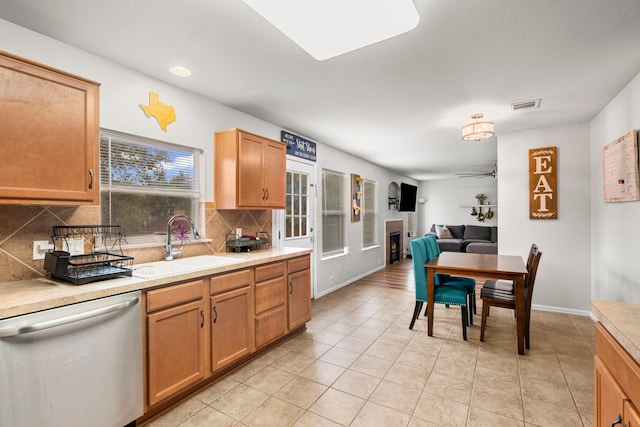 kitchen with ceiling fan, dishwasher, decorative backsplash, sink, and light tile patterned floors