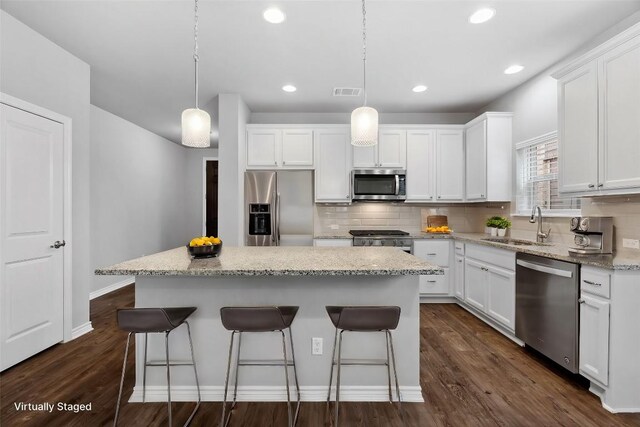 kitchen with white cabinets, stainless steel appliances, and a center island