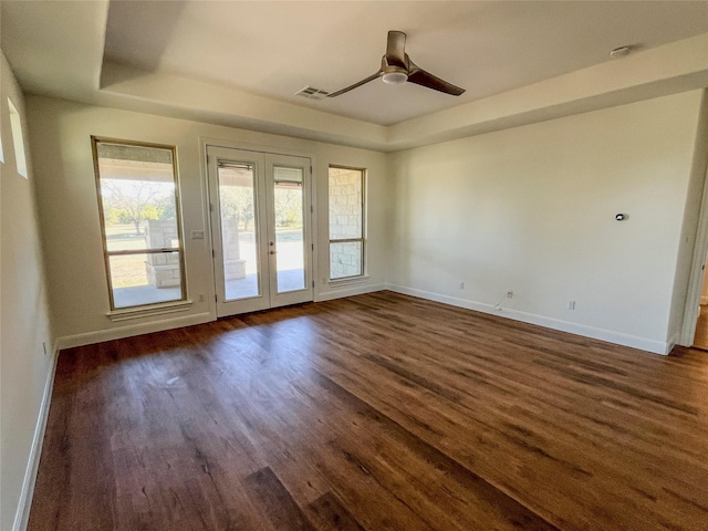 spare room featuring french doors, a raised ceiling, ceiling fan, and dark wood-type flooring