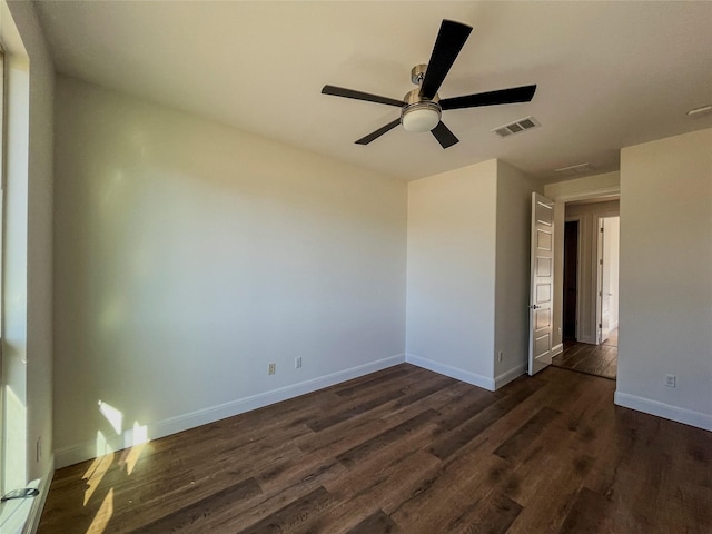 spare room with dark hardwood / wood-style flooring and ceiling fan