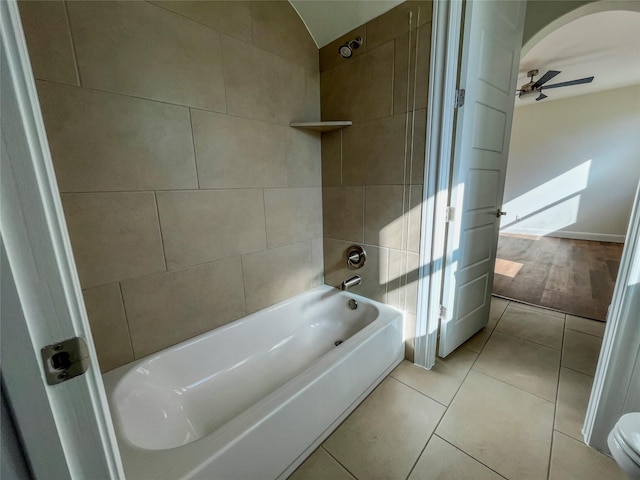 bathroom featuring toilet, tile patterned floors, tiled shower / bath combo, and ceiling fan