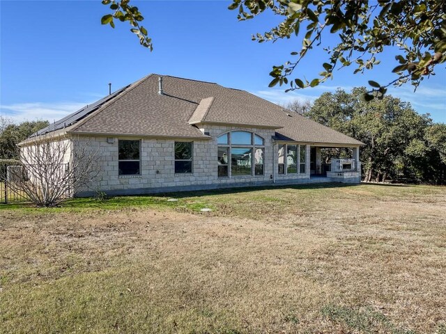 312 Brave Face St, Leander, TX 78641 - rear view of property featuring roof with shingles, a lawn, and stone siding