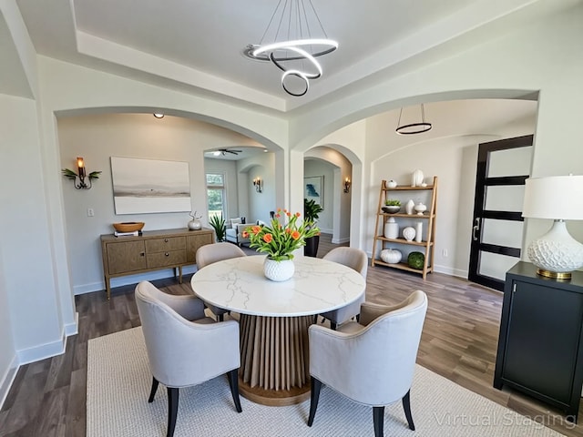 312 Brave Face St, Leander, TX 78641 - dining area with arched walkways, dark wood finished floors, a chandelier, and a tray ceiling