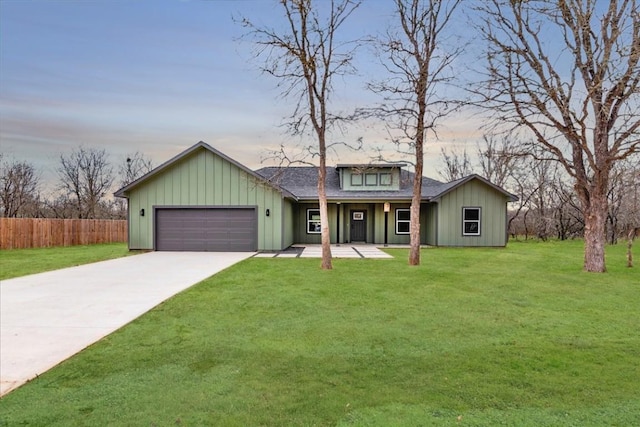 view of front of home featuring fence, an attached garage, driveway, and a front lawn