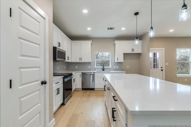 kitchen with white cabinetry, appliances with stainless steel finishes, and a center island