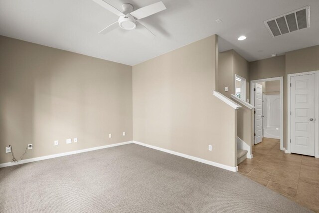 empty room featuring ceiling fan and light carpet