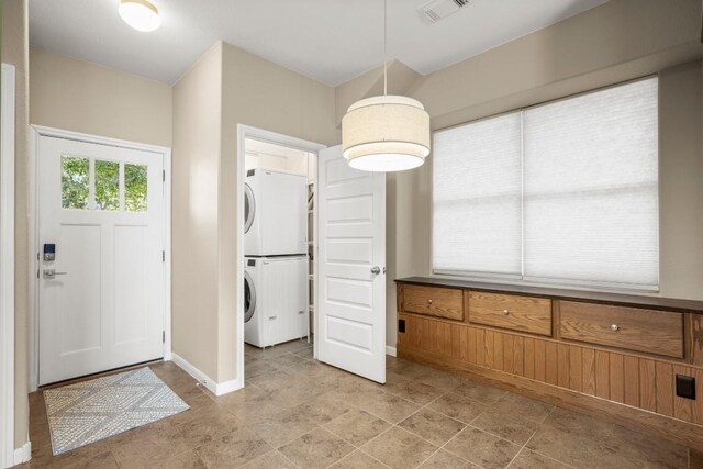 clothes washing area featuring stacked washer / dryer