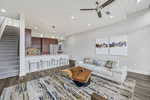 living room with ceiling fan and dark wood-type flooring