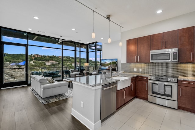 kitchen with ceiling fan, decorative light fixtures, tasteful backsplash, sink, and stainless steel appliances