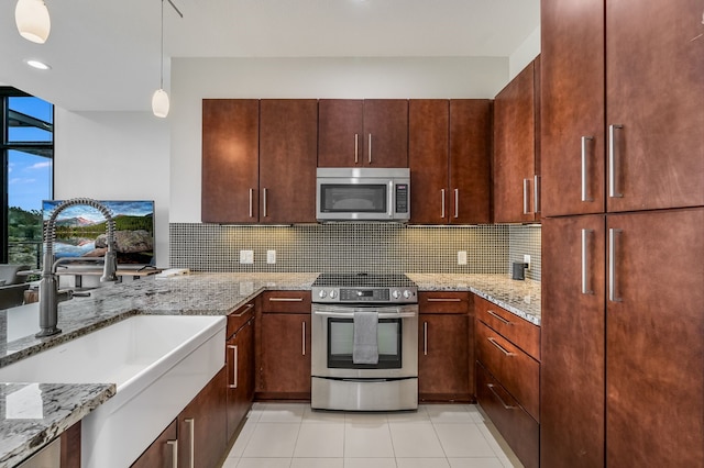 kitchen featuring stainless steel appliances, backsplash, decorative light fixtures, light tile patterned flooring, and sink