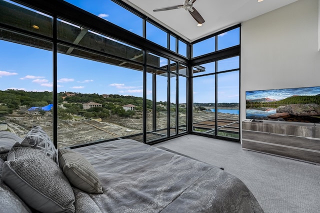 bedroom featuring carpet floors, a wall of windows, and ceiling fan