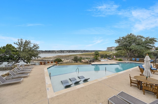 view of pool featuring a water view and a patio area