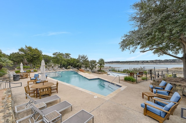 view of swimming pool featuring a patio area and a water view