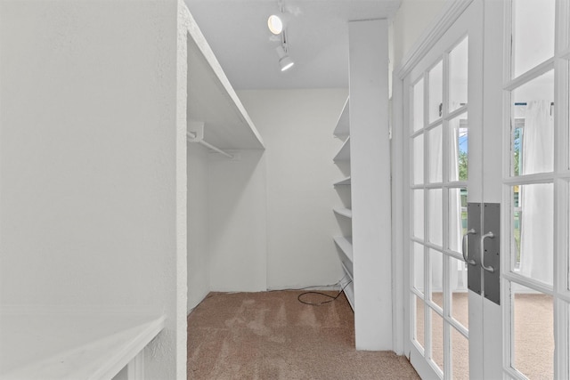 walk in closet with carpet and french doors