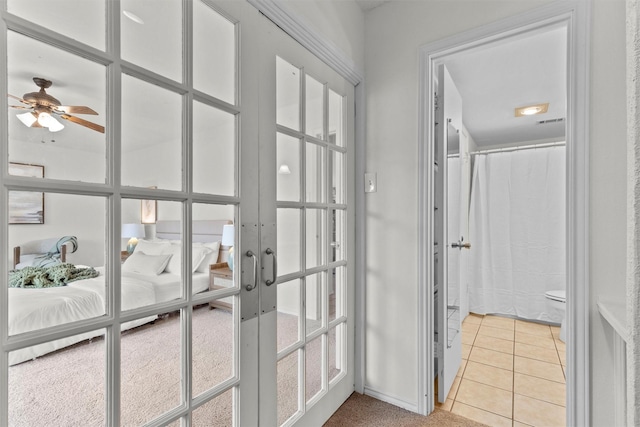 entryway featuring ceiling fan, french doors, and light tile patterned flooring