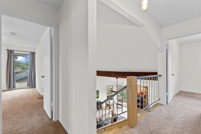 hall with a textured ceiling and carpet flooring