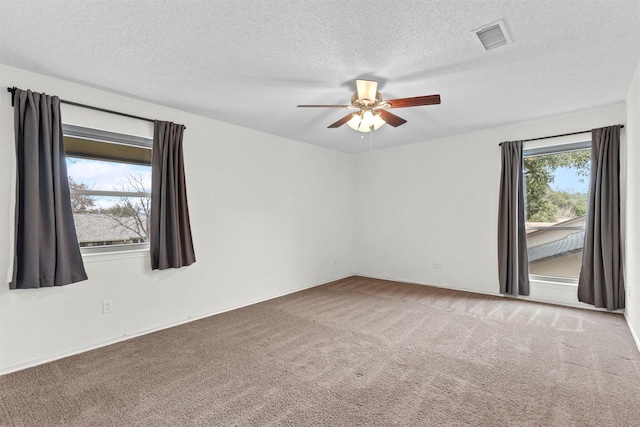 spare room with carpet, ceiling fan, and a textured ceiling